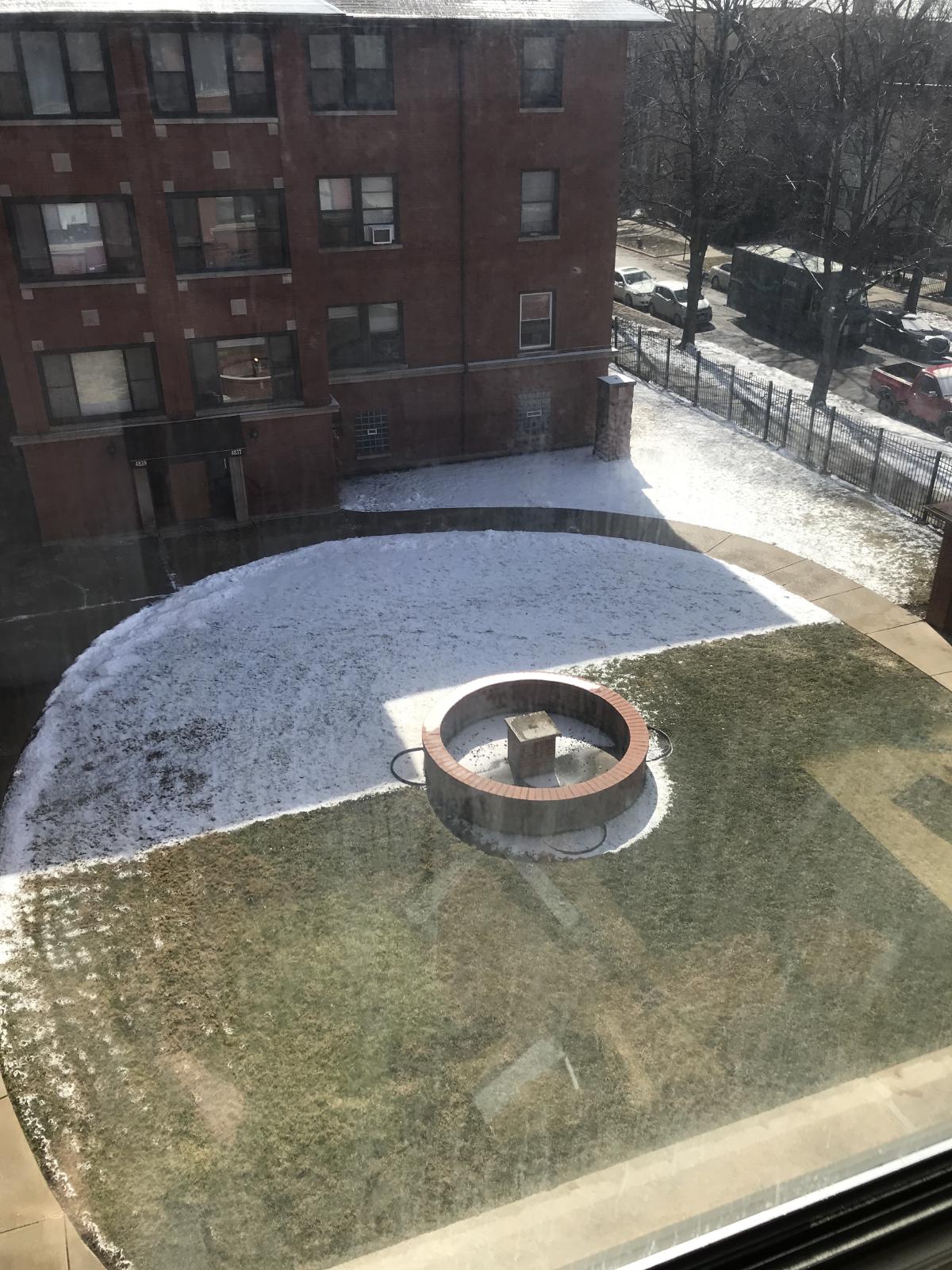 our courtyard with snow only where a shadow is cast by the building