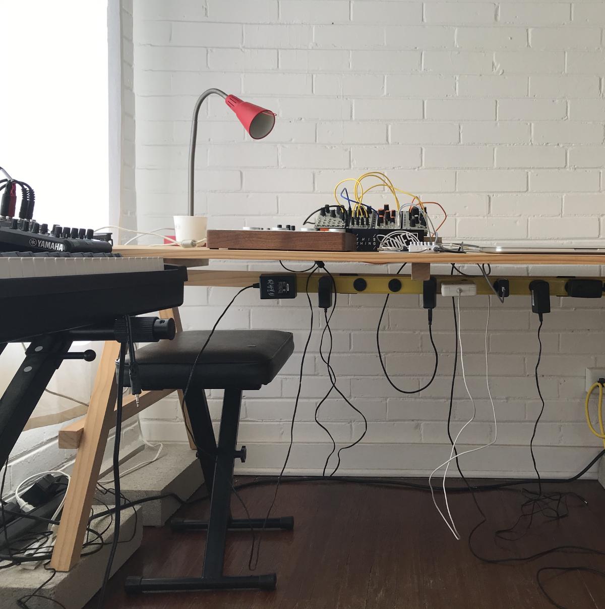 brick wall studio room with keyboard and synthesizers on wodden desk