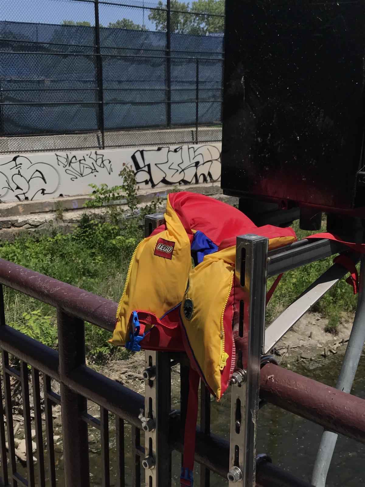 a lego life jacket on the railing of abridge for some reason