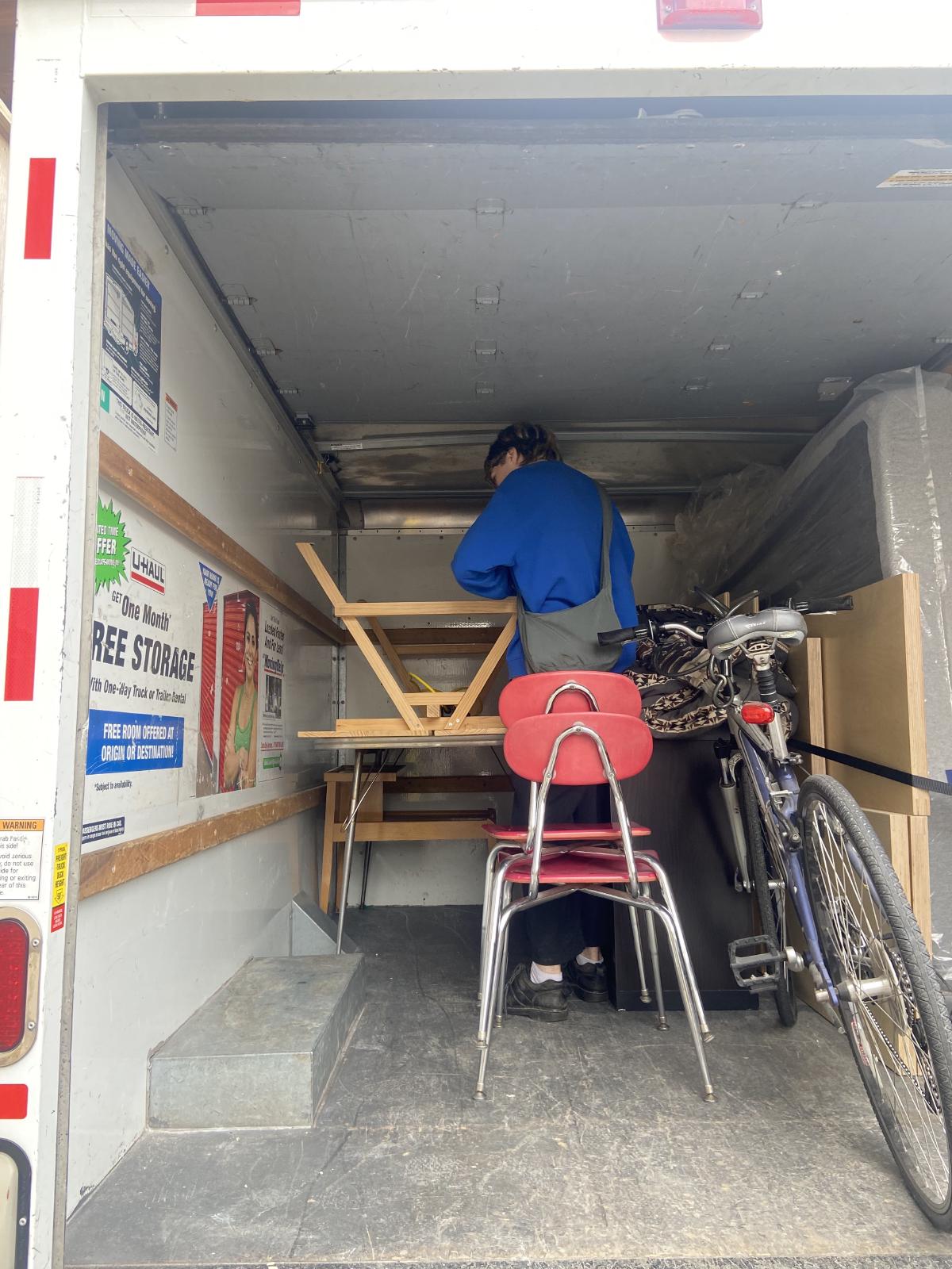 and in a moving truck positioning a desk