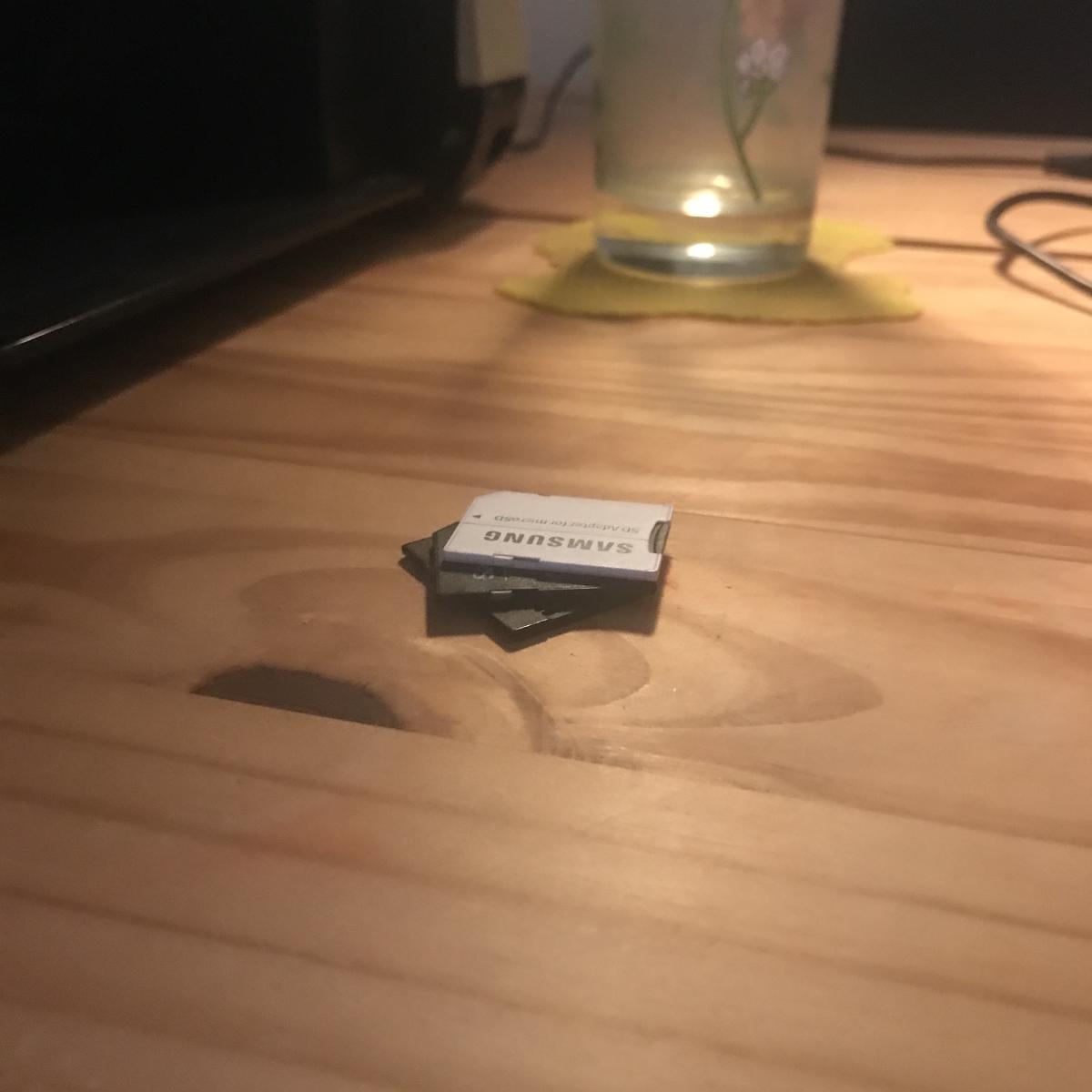 a pile of sd cards on a wodden desk at night