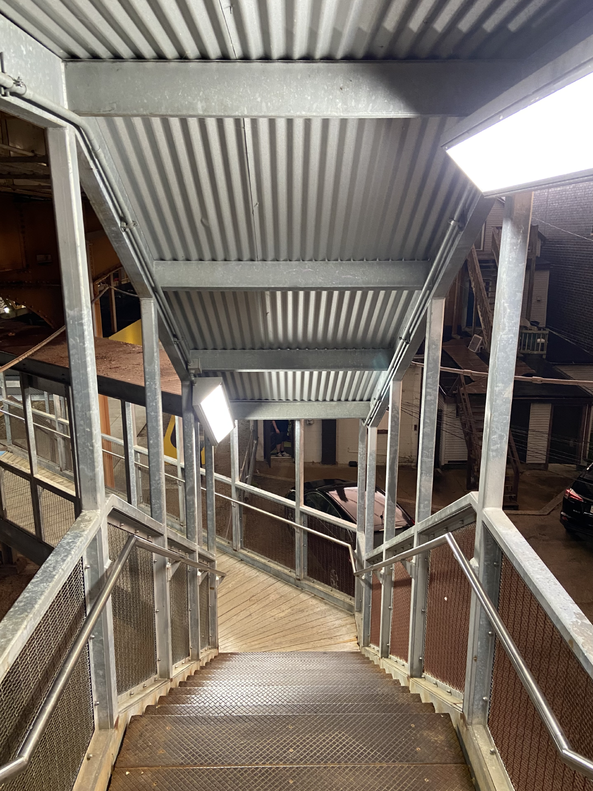winding stairwell at night bright lights with tin rooftop