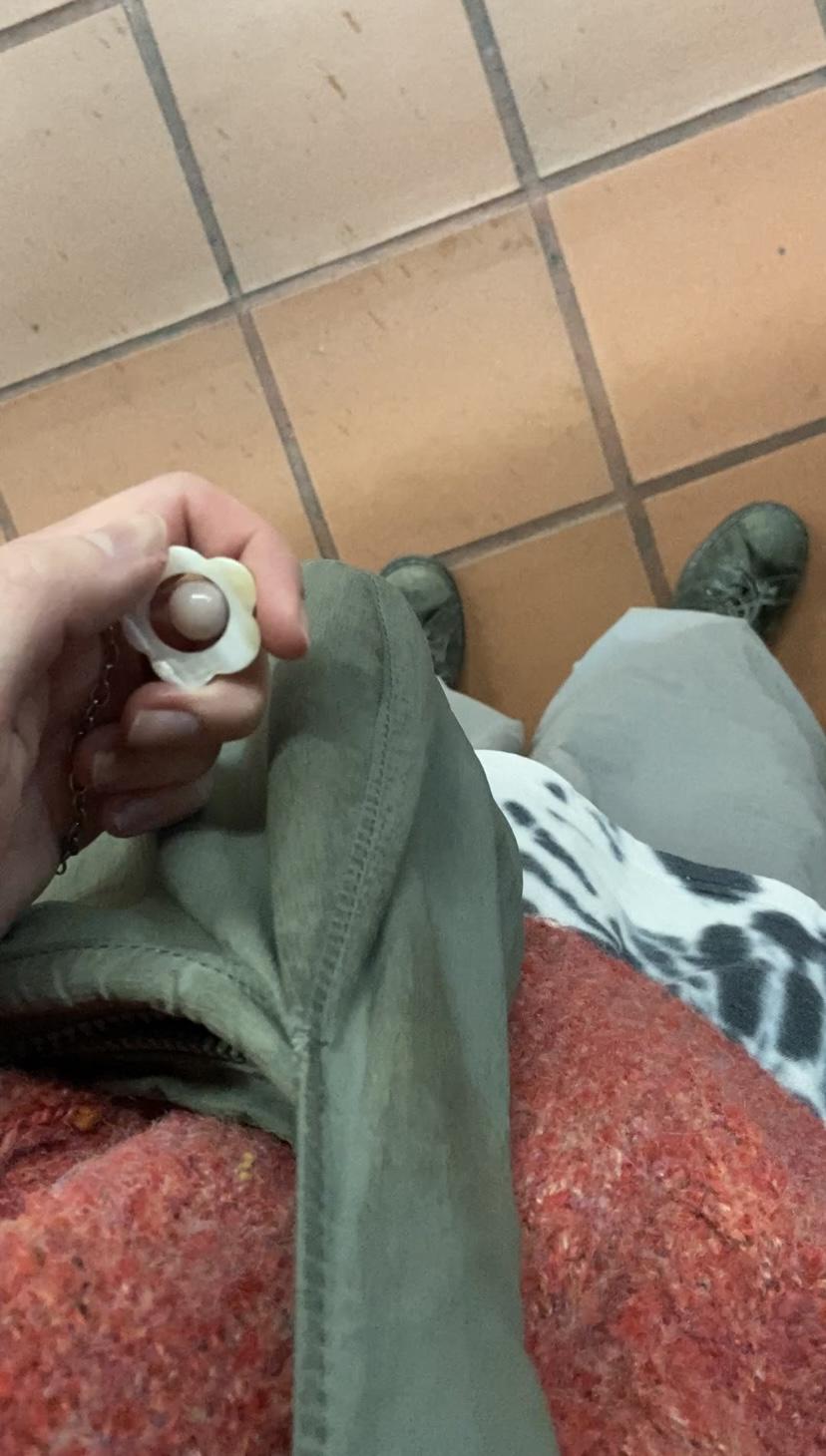 and in a red sweater holding a flower shaped spinning pendant